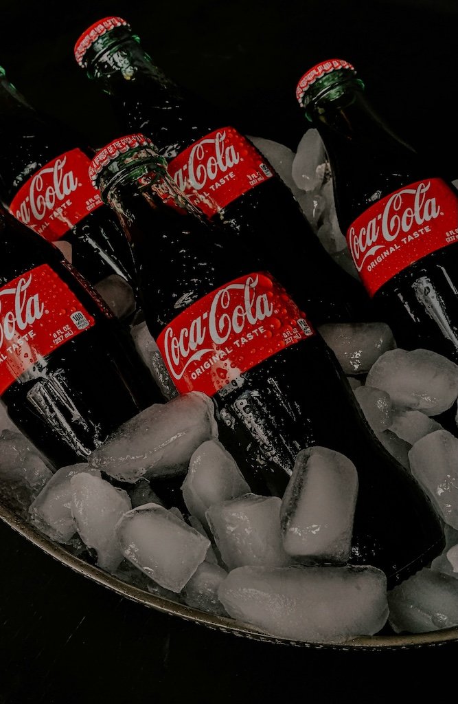 Eisgekühlte Coca-Cola Flaschen auf Eiswürfeln